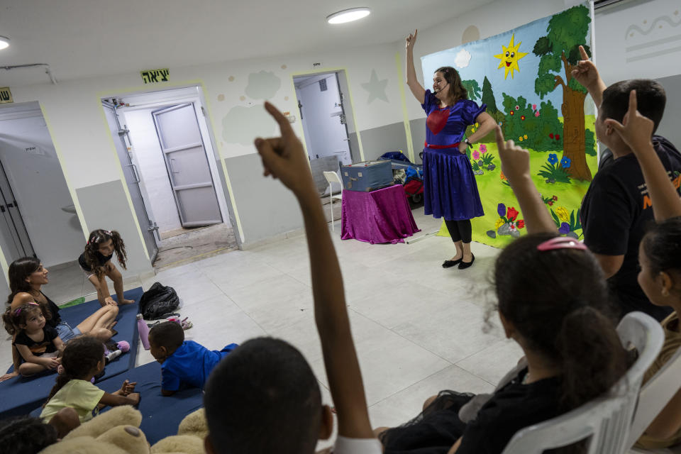 An entertainer performs a children's show in a neighbourhood's bomb shelter in Ashkelon, Israel, Tuesday, Oct. 31, 2023. (AP Photo/Bernat Armangue)