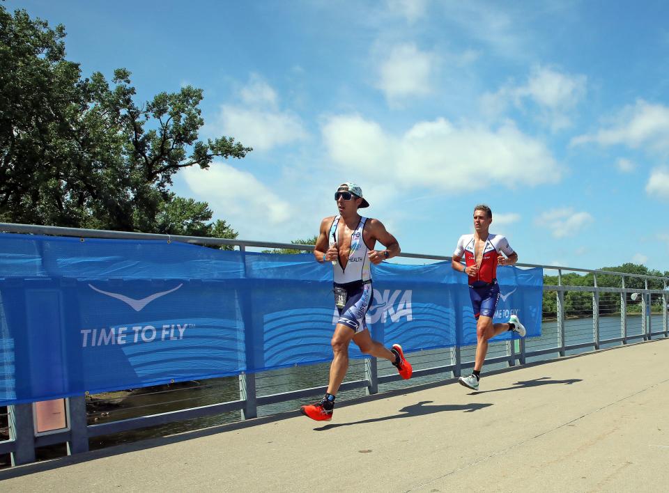 Runners race along the Kruidenier Trail Bridge during the inaugural edition of the Ironman 70.3 mile Des Moines Triathlon as athletes compete in a 1.2-mile swim at Gray’s Lake, 56.0 mile bike race (shortened due to 3-hour rain delay), and a 13.1 mile run in Des Moines.