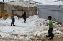 A Syrian refugee child shovels snow outside a tent in Aarsal town in Lebanon's eastern Bekaa December 13, 2013. A powerful winter storm sweeping the eastern Mediterranean this week is causing mayhem across the region. The storm, named Alexa, is expected to last until Saturday, bringing more snow, rain and freezing temperatures to large swathes of Turkey, Syria, Lebanon, Jordan, Israel and the Palestinian territories. The bad weather, which began on Wednesday, is taking a disproportionate toll on the 2.2 million refugees living outside Syria and the 6.5 million people displaced within the country. REUTERS/Ahmad Shalha (LEBANON - Tags: ENVIRONMENT)