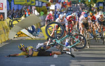 Dutch cyclist Dylan Groenewegen crashes to the ground as a bicycle is flying overhead in a major collision on the final stretch of the opening stage of the Tour de Pologne race in Katowice, Poland, on Wednesday, Aug. 5, 2020. The crash began with Groenewegen colliding with another Dutchman sprinting for the win, Fabio Jakobsen, who was hospitalized in serious condition and put into an induced coma. Jakobsen was declared the winner of the opening stage and Groenewegen was disqualified. (AP Photo/Tomasz Markowski)