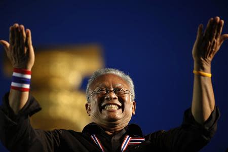 Suthep Thaugsuban, former deputy Prime Minister and protest leader, acknowledges the crowd at the Democracy monument in central Bangkok, where tens of thousands gathered in a protest against a government-backed amnesty bill, November 24, 2013. REUTERS/Damir Sagolj