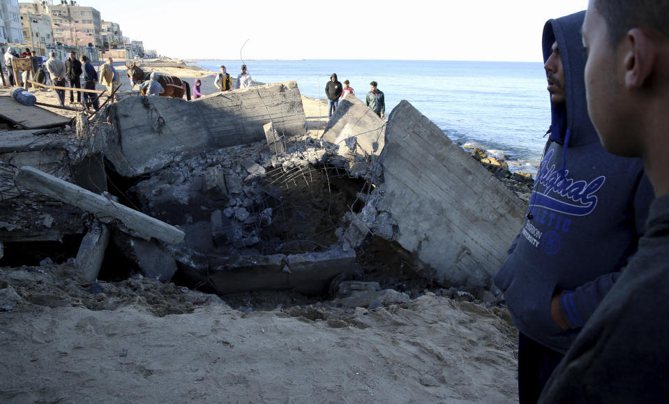 Residents gather around the rubble of destroyed sewage pipes following overnight Israeli missile strikes, along the beach of Shati refugee camp, in Gaza City, Thursday, Feb. 6, 2020. Earlier on Wednesday, Israel struck Hamas militant targets in Gaza in response to rocket fire toward Israeli communities the previous night. (AP Photo/Adel Hana)