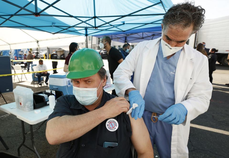 Matthew Oines gets the Pfizer vaccine shot from Dr. Steven Florman MD medical director of Stacy Medical Center