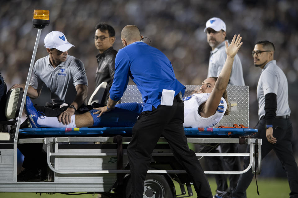 Buffalo punter Evan Finegan (40) waves to the crowd as he is carted off the field after suffering a leg injury in the third quarter of an NCAA college football game in State College, Pa., on Saturday, Sept. 7, 2019. (AP Photo/Barry Reeger)