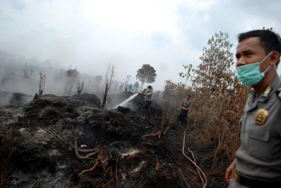 Police extinguish a fire in Kampar, Indonesia