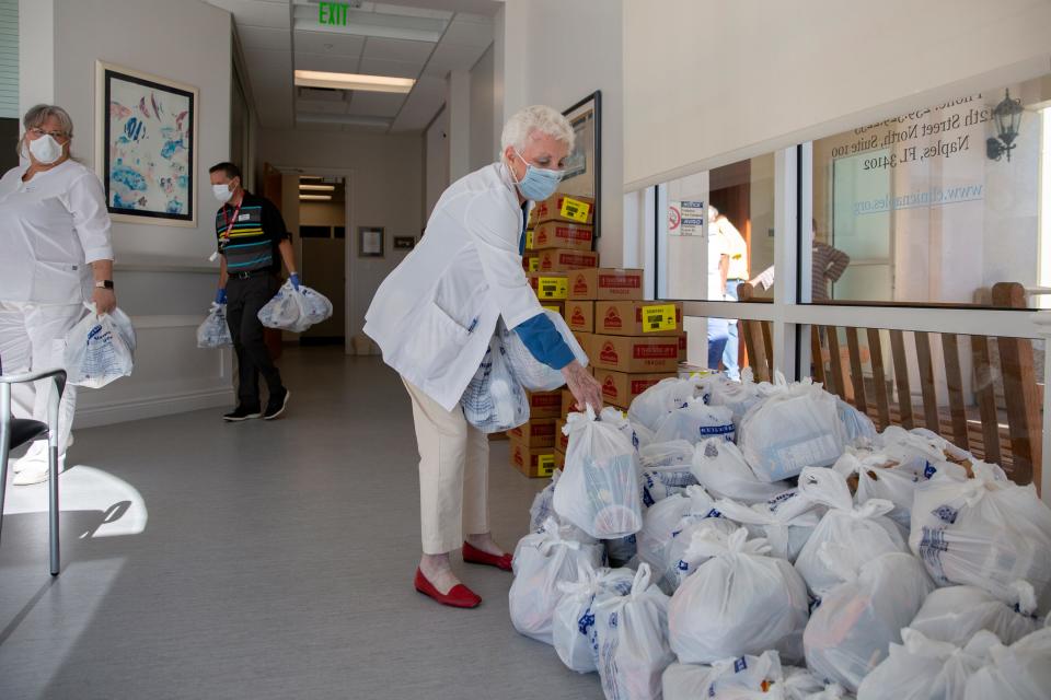 Neighborhood Health Clinic co-founder Nancy Lascheid, stack bags of donated goods from St. Matthew's House, Friday, May 1, 2020,  in Naples.