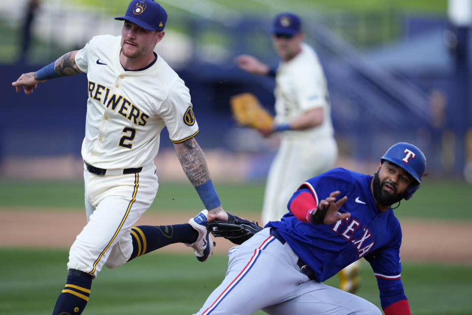 Texas Rangers' Derek Hill is caught stealing by Milwaukee Brewers' Brice Turang (2) during the second inning of a spring training baseball game, Saturday, March 16, 2024, in Phoenix. (AP Photo/Matt York)