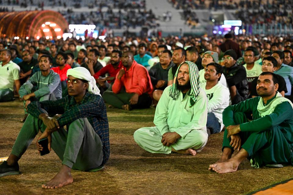 Qatar's migrant workers watch the Qatar 2022 World Cup round of 16 football match between Morocco and Spain on December 6, 2022, at the Asian Town cricket stadium, on the outskirts of Doha. - The stadium has become a daily draw for thousands of the poorest workers who live in nearby dormitories away from Doha's glitzy shopping malls and restaurants. (Photo by INA FASSBENDER / AFP) (Photo by INA FASSBENDER/AFP via Getty Images)