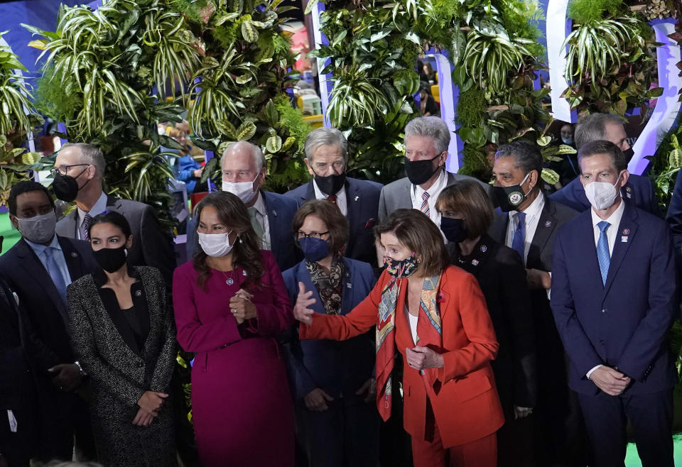 Nancy Pelosi, Speaker of the United States House of Representatives, front, and U.S. Rep. Alexandria Ocasio-Cortez, second left, and other US politicians prepare for a group photo after arriving at the venue of the COP26 U.N. Climate Summit in Glasgow, Scotland, Tuesday, Nov. 9, 2021. The U.N. climate summit in Glasgow has entered it's second week as leaders from around the world, are gathering in Scotland's biggest city, to lay out their vision for addressing the common challenge of global warming. (AP Photo/Alberto Pezzali)