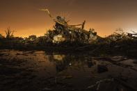 A car rests on top of a pile of debris pushed up by the wind in an area heavily damaged by the May 20 afternoon tornado in Moore, Oklahoma May 27, 2013. The tornado was the strongest in the United States in nearly two years and cut a path of destruction 17 miles (27 km) long and 1.3 (2 km) miles wide. (REUTERS/Lucas Jackson)