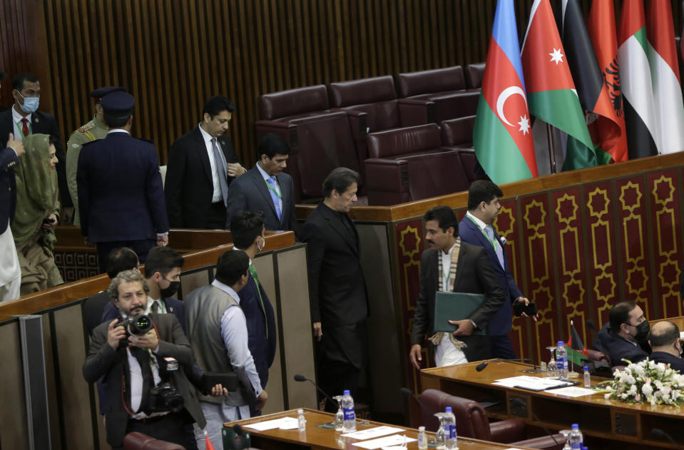 Pakistan's Prime Minister Imran Khan, center, arrives for the 17th extraordinary session of Organization of Islamic Cooperation (OIC) Council of Foreign Ministers, in Islamabad, Pakistan, Sunday, Dec. 19, 2021. The economic collapse of Afghanistan, already teetering dangerously on the edge, would have a "horrendous" impact on the region and the world, successive speakers warned Sunday at the start of a one-day summit of foreign ministers. (AP Photo/Rahmat Gul)