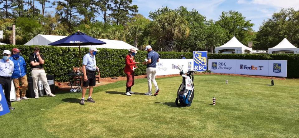 Henry Pratt gives a score card to world No. 1 Dustin Johnson at the first tee of the RBC Heritage Saturday. Pratt announces players on the first tee. “I think it makes the players feel better -- appreciated,” Pratt says of his introductions.