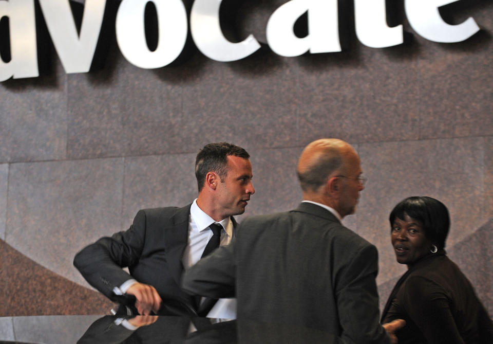 Oscar Pistorius, left, leaves the high court building in Pretoria, South Africa, Monday, March 3, 2014 during a lunch break. Pistorius is charged with murder with premeditation in the shooting death of girlfriend Reeva Steenkamp in the pre-dawn hours of Valentine's Day 2013. (AP Photo) SOUTH AFRICA OUT