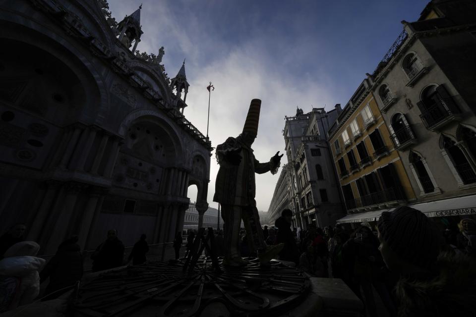 Un hombre vestido de arlequín interactúa con visitantes durante el Carnaval, en Venecia, el 28 de enero de 2024. Venecia conmemora el 700 aniversario de la muerte de Marco Polo con un año de actos que comenzaron con un inicio del Carnaval dedicado a uno de los hijos más ilustres de la ciudad de los canales. (AP Foto/Luca Bruno)