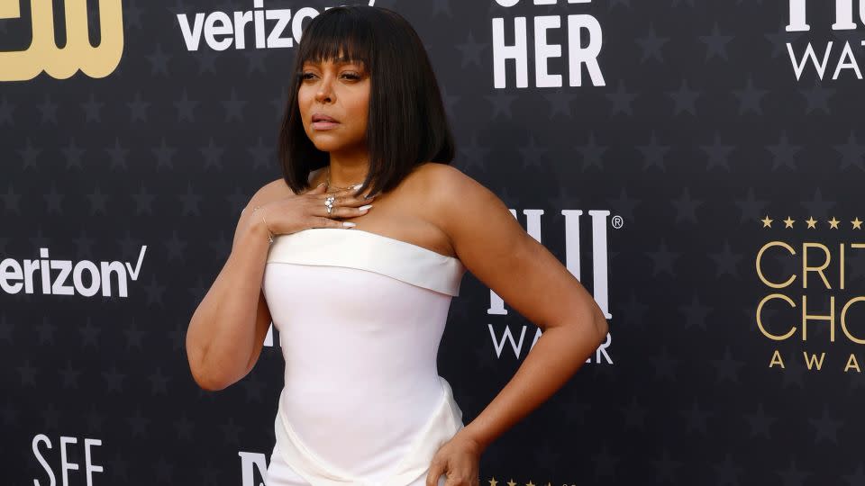 “The Color Purple” actor Taraji P. Henson in a white strapless Boss dress with cream detailing, peek-a-boo leg slit and pointy silver pumps. - Frazer Harrison/Getty Images