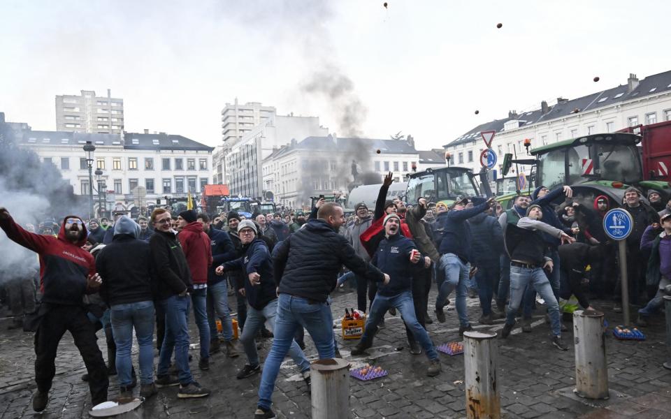 Farmers threw eggs at riot police who set up barbed-wire fences to block their path outside the European Parliament