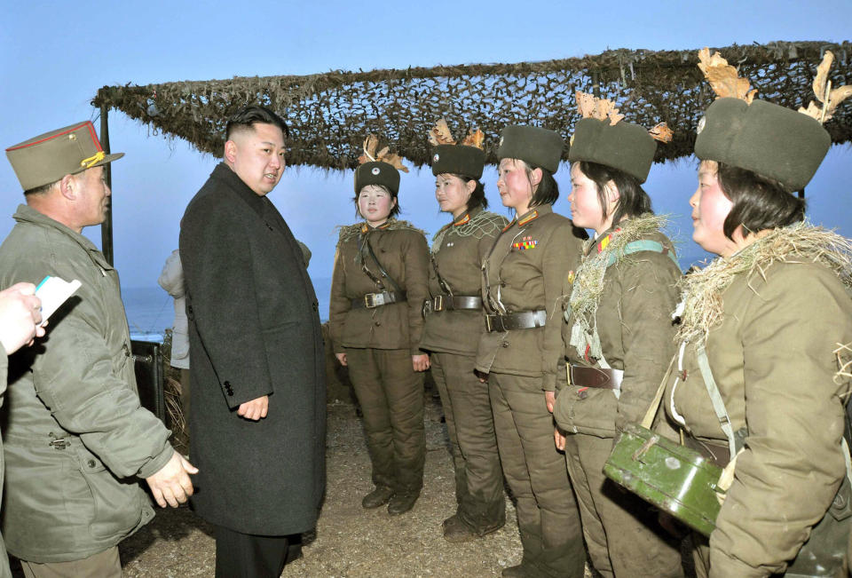 This picture released by North Korea's official Korean Central News Agency on March 26, 2013 and taken on March 25, 2013 shows North Korean leader Kim Jong-Un (C) speaking with female artilleries during his inspection of the landing and anti-landing drills of KPA Large Combined Units 324 and 287 and KPA Navy Combined Unit 597 at an undisclosed location on North Korea's east coast.