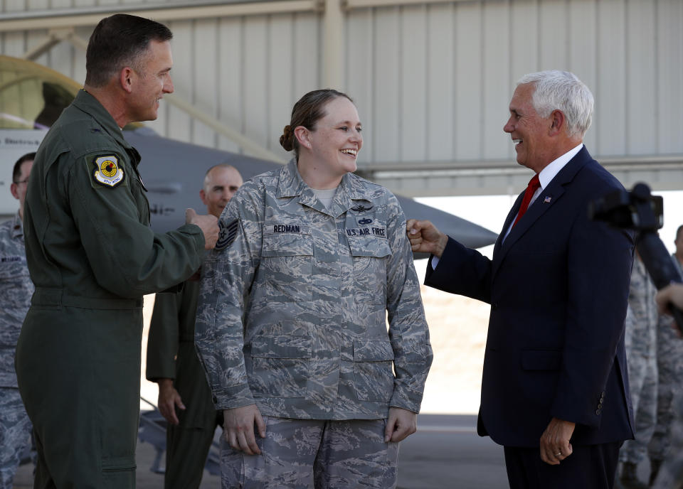 Staff Sgt. Vanessa Redman, center, is "tacked" by Brig. Gen, Rob Novotny, left, and Vice President Mike Pence after being promoted to technical sergeant on a Nellis Air Force Base flight line in Las Vegas, Friday, Sept. 7, 2018. (Steve Marcus/Las Vegas Sun via AP)