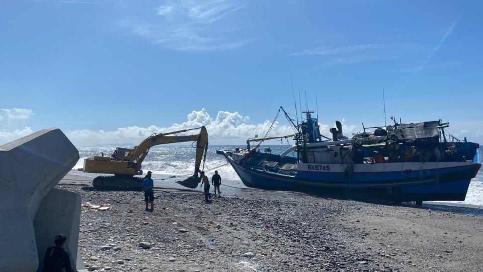 「金鴻益號」漁船遭浪拍打至岸際導致擱淺，怪手拖不動。海巡署第一三岸巡隊提供