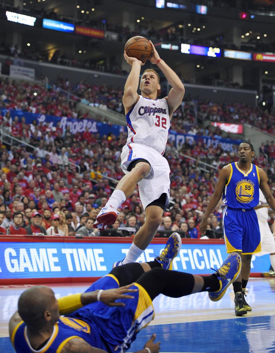 Los Angeles Clippers forward Blake Griffin, top, puts up a shot as he fouls Golden State Warriors forward Marreese Speights, below, while guard Jordan Crawford looks on during the first half in Game 1 of an opening-round NBA basketball playoff series, Saturday, April 19, 2014, in Los Angeles. (AP Photo/Mark J. Terrill)