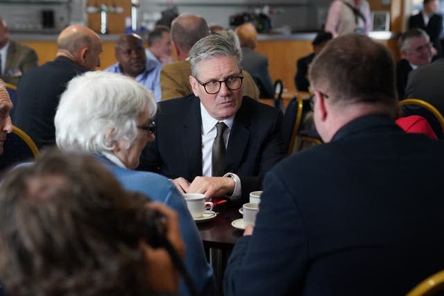 Labour Party leader Sir Keir Starmer sits at a table and talks to people during a visit to a veterans’ coffee morning in Hampshire