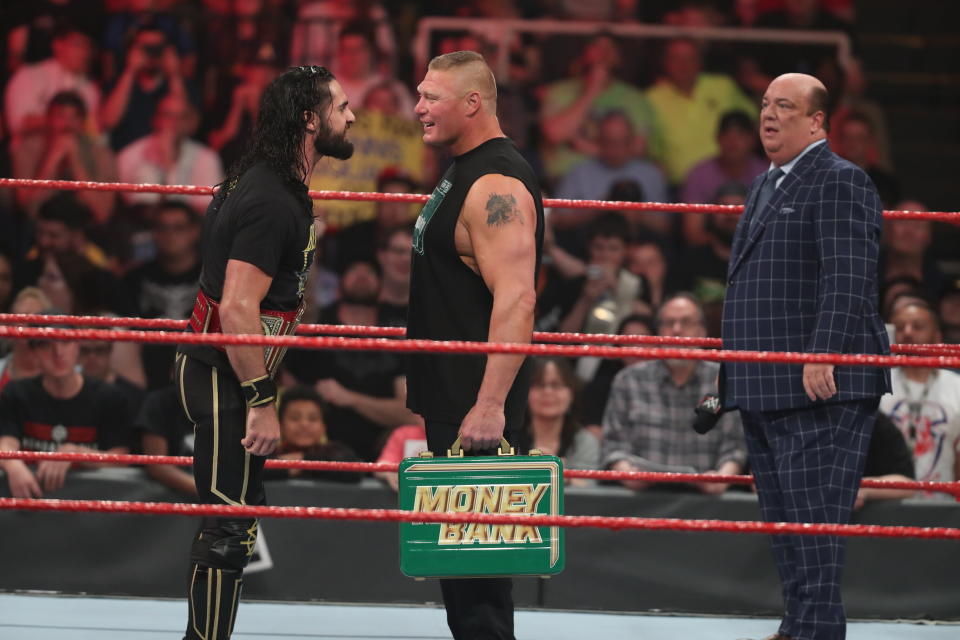 Paul Heyman looks on as Brock Lesnar and Seth Rollins taunt one another. (Photo courtesy of WWE)