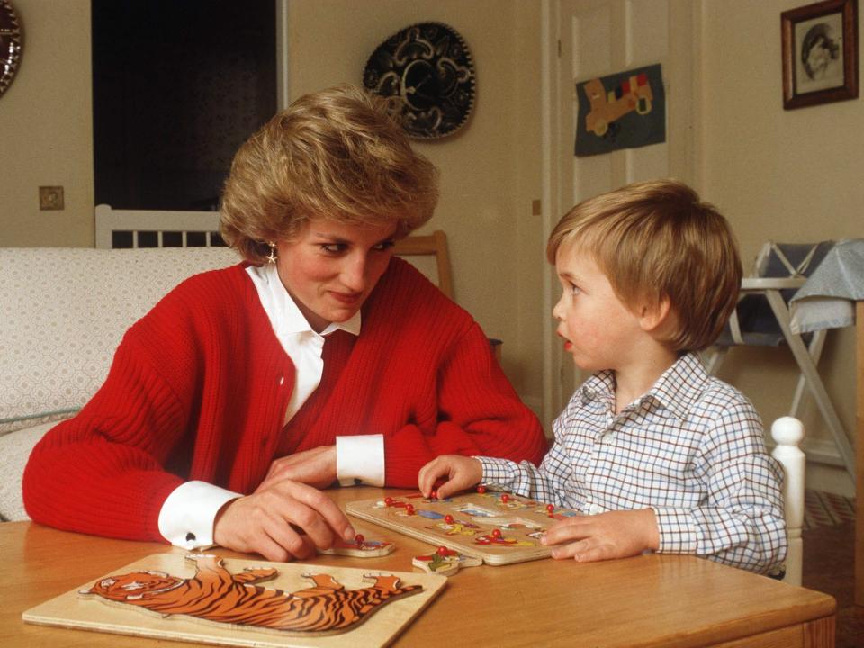 princess diana sitting with prince william at a table playing with a puzzle