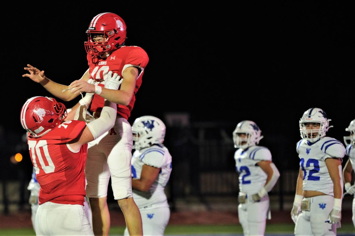 Albany lineman Zane Waggoner (70) celebrates with quarterback Cole Chapman as Windthorst defenders look on. The celebration came after Chapman's 34-yard TD run gave the Lions a 14-0 lead with 7:09 left in the first quarter. Albany won the Region II-2A Division II championship game 28-14 on Dec. 3 at Newton Field in Graham.