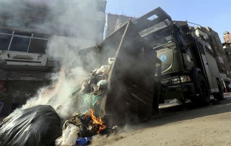 An armoured personnel vehicle is used to remove rubbish set on fire after clashes with supporters of the Muslim Brotherhood and ousted Egyptian President Mohamed Mursi in the Cairo suburb of Matariya November 28, 2014. REUTERS/Mohamed Abd El Ghany