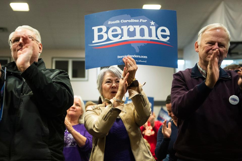 From left, Robert Herrick and Ann and Terry Bailey applaud speakers at the end of an event held by Bernie Sanders' campaign at the West End Community Development Center in Greenville, S.C., on Feb. 15.