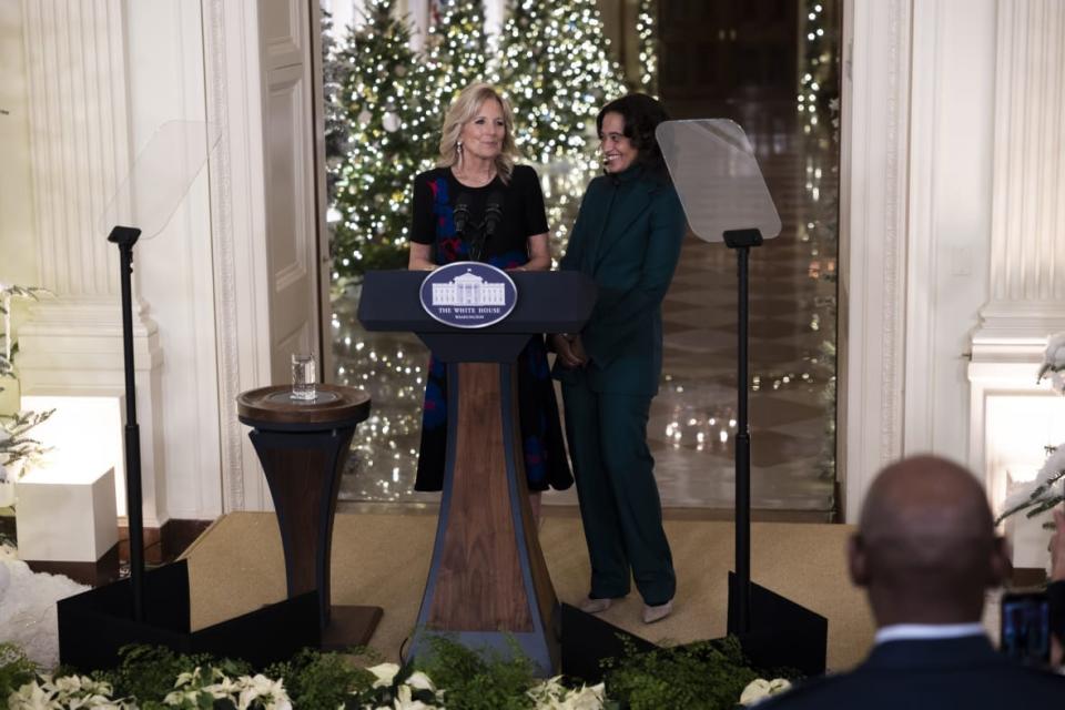 Daria Peoples, an elementary school art teacher and children’s book author from Las Vegas, Nevada, who illustrated the 2022 White House Holiday Guide, stands alongside First Lady Dr. Jill Biden as she speaks about her “We The People” theme for the White House Christmas decorations in the East Room in Washington, DC on November 28th, 2022. (Photo by Nathan Posner/Anadolu Agency via Getty Images)