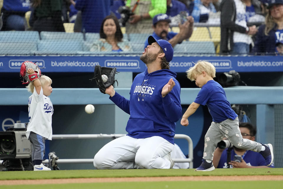 Los Angeles Dodgers' Clayton Kershaw, center, plays with his kids, Chance, left, and Cooper prior to a baseball game against the Chicago White Sox Thursday, June 15, 2023, in Los Angeles. (AP Photo/Mark J. Terrill)