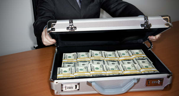 Man holding silver briefcase full of $100 bills