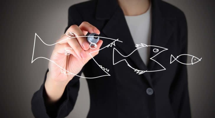 businesswoman drawing large fish eating small fish to represent large-cap stock index funds