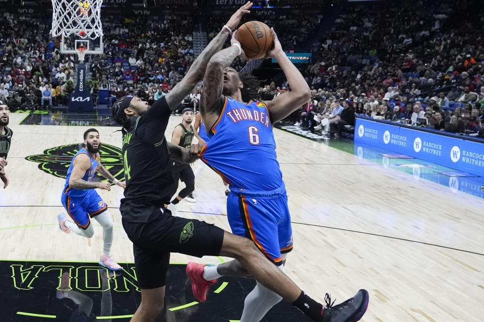 Oklahoma City Thunder forward Jaylin Williams (6) is tugged on the jersey by New Orleans Pelicans forward Brandon Ingram as he shoots in the first half of an NBA basketball game in New Orleans, Friday, Jan. 26, 2024. (AP Photo/Gerald Herbert)