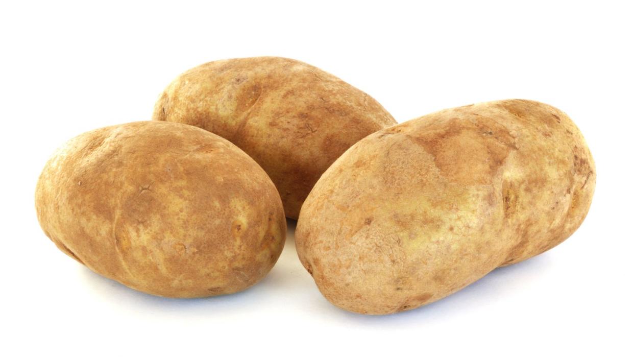 three raw russet potatoes