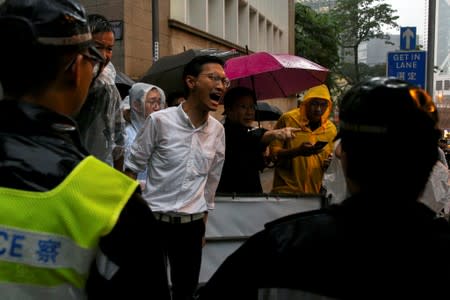 A pro-democracy legislator reacts to riot police officers as he walks toward the Government House following a day of violence over an extradition bill that would allow people to be sent to mainland China for trial in Hong Kong