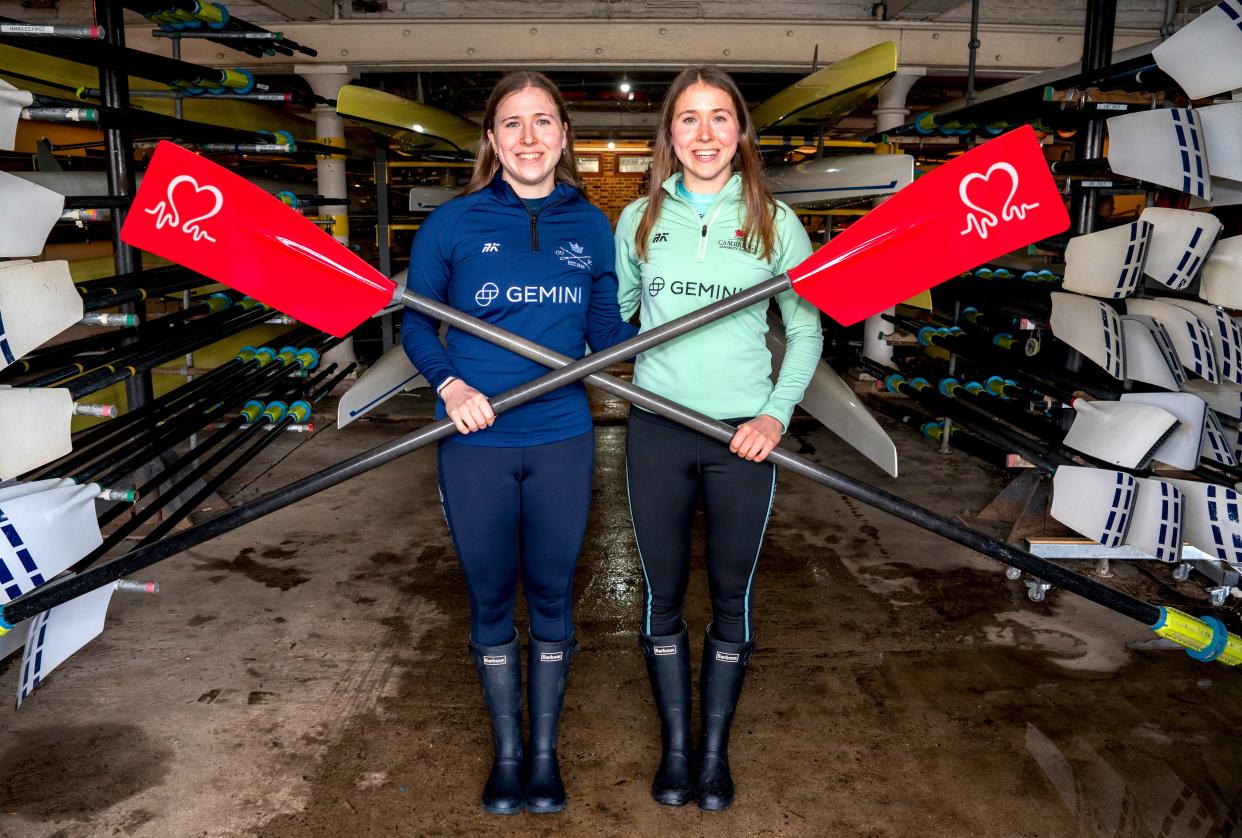 Catherine and Gemma King standing in a boathouse holding oars