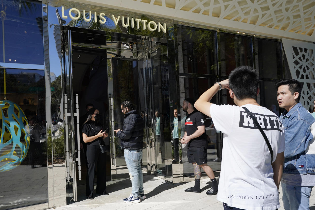 Shoppers line up to enter the new Louis Vuitton menswear store in the Miami's Design District, Tuesday, Nov. 30, 2021, in Miami. Virgil Abloh, Louis Vuitton's first Black artistic director, died of cancer. He was 41. (AP Photo/Marta Lavandier)