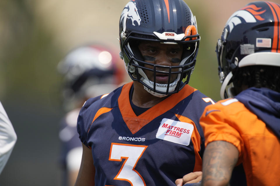 Denver Broncos quarterback Russell Wilson, left, talks with wide receiver KJ Hamler as they take part in drills during the NFL team's practice at the Broncos' headquarters Monday, June 13, 2022, in Centennial, Colo. (AP Photo/David Zalubowski)