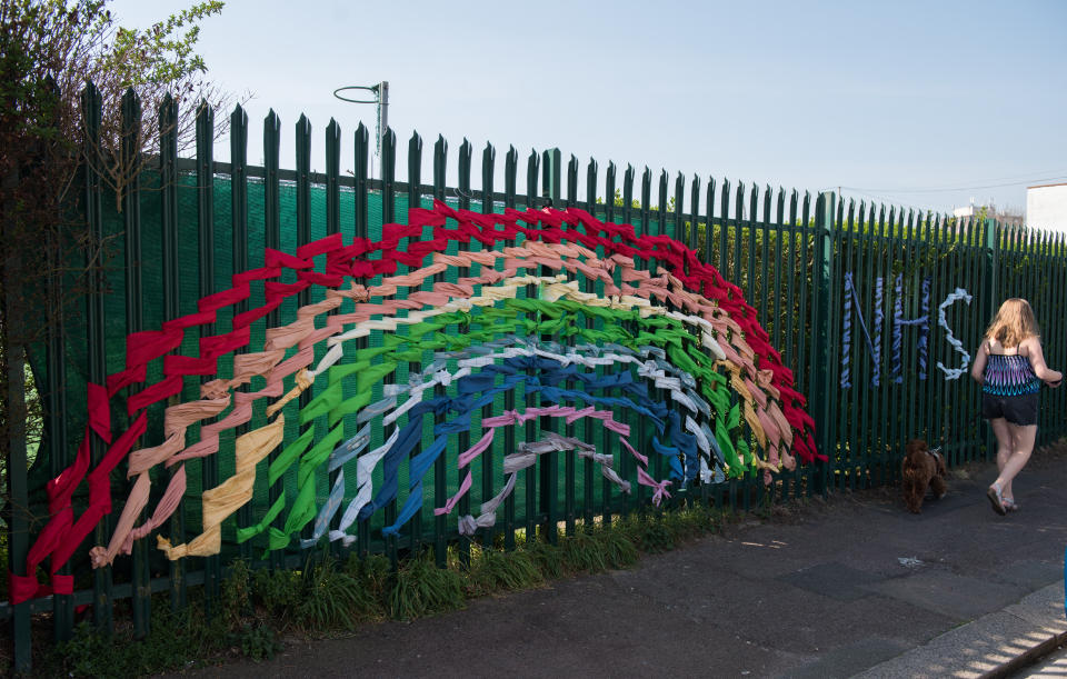 LEIGH ON SEA - APRIL 10: A rainbow and NHS is made of cloth ribbons and woven into a fence of a primary school on April 10, 2020 in Leigh on Sea, England. Public Easter events have been cancelled across the country, with the government urging the public to respect lockdown measures by celebrating the holiday in their homes. Over 1.5 million people across the world have been infected with the COVID-19 coronavirus, with over 7,000 fatalities recorded in the United Kingdom.   (Photo by John Keeble/Getty Images)