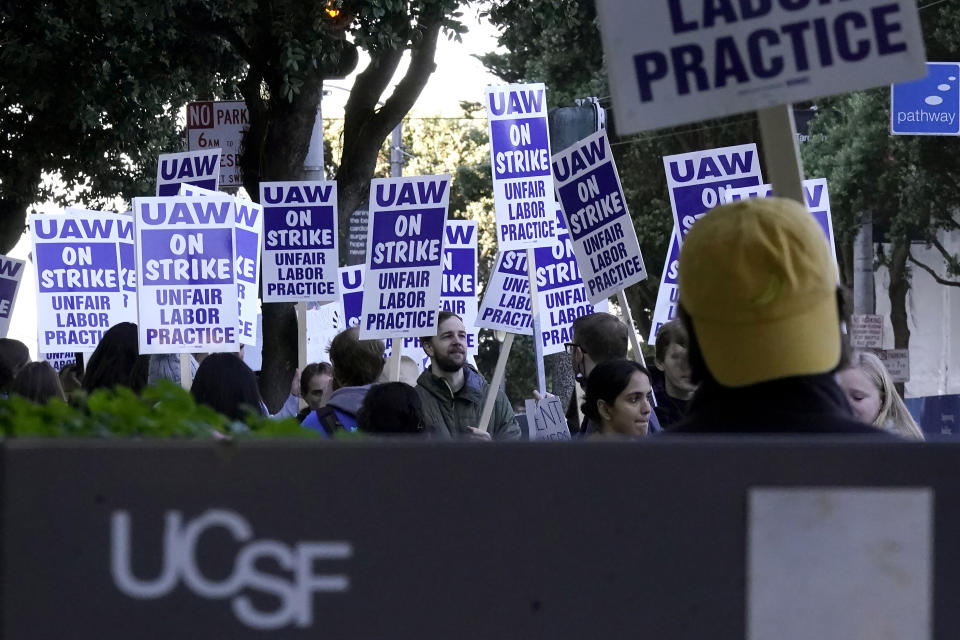 People take part in a protest outside of University of California San Francisco medical offices in San Francisco, Monday, Nov. 14, 2022. Nearly 48,000 unionized academic workers at all 10 University of California campuses have walked off the job Monday. (AP Photo/Jeff Chiu)