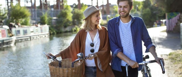 Couple smiling and walking along canal with bikes