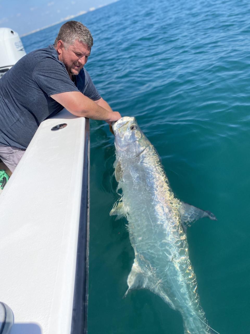 Donald Schnitzler makes peace with a tarpon estimated at 100 pounds, caught from Capt. Jeff Patterson's Pole Dancer charter boat.