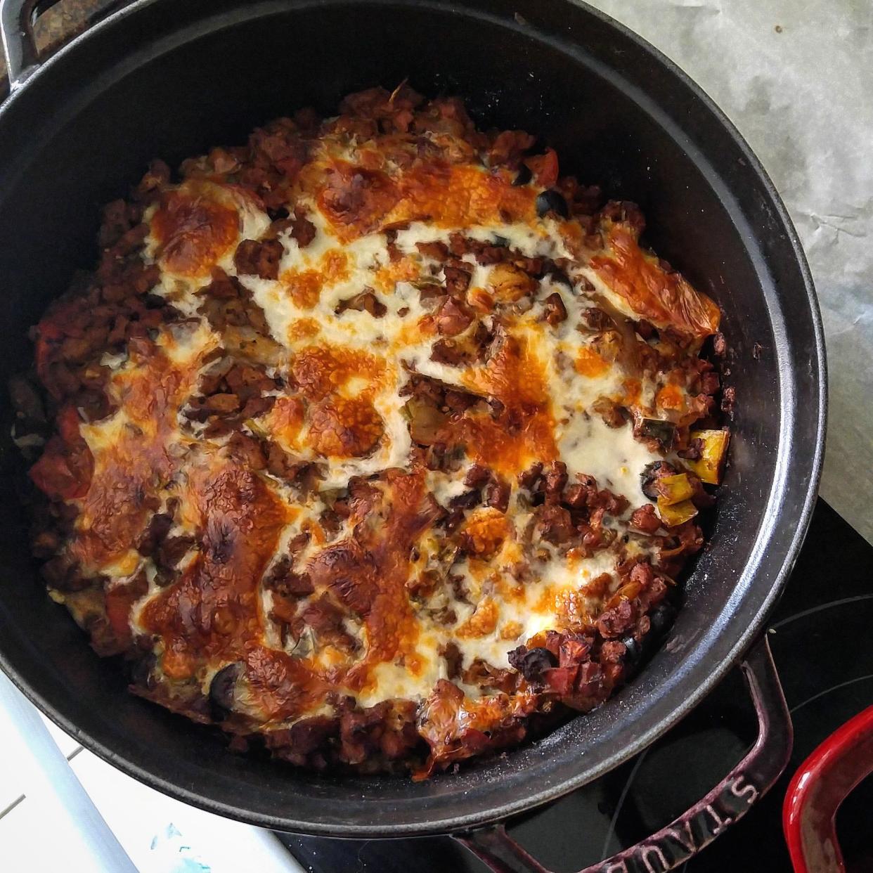 Two Dutch ovens get filled with layers of a homemade soy-based "faux-sage", a two-onion ragú and homemade gnocchi before being topped off with fresh mozzarella cheese and baked to bubbling perfection