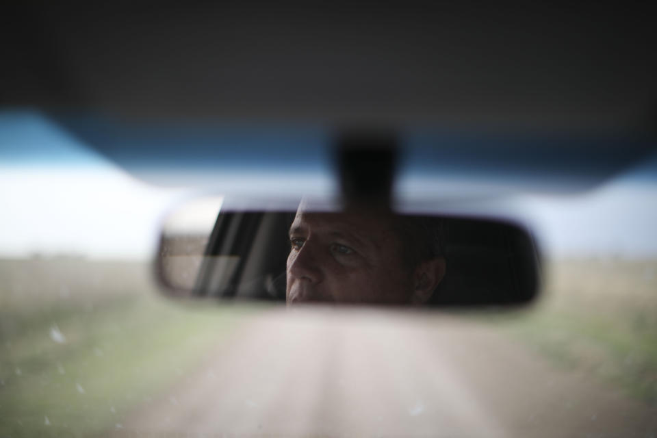 In this Oct. 9, 2019 photo, farmer Juan Rossi is reflected in his rearview mirror on the outskirts of Pergamino, Argentina. Farmers like Rossi are bracing for a return of interventionist policies if a populist ticket returns to power. Export restrictions under former President Cristina Fernandez triggered a revolt by farmers in 2008 in one of the world's top suppliers of grains. (AP Photo/Natacha Pisarenko)