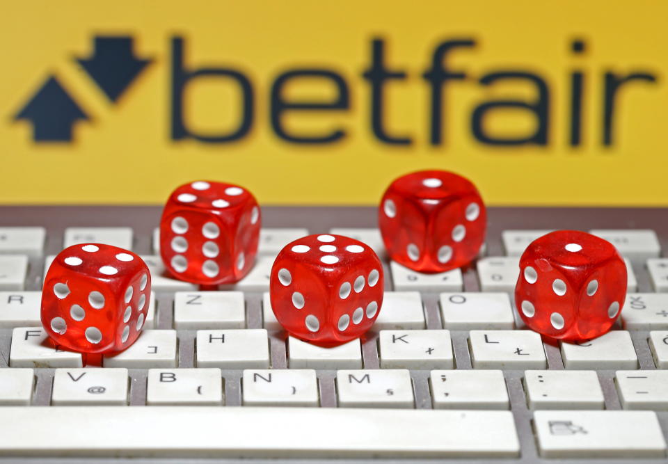 Betfair logo is seen behind a keyboard and gambling dice in this illustration taken in Sarajevo, September 10, 2015. Betfair and Irish rival Paddy Power have reached agreement on a 6 billion pound combination, first set out last month and designed to secure leadership of Britain's competitive online gambling market. As in a provisional deal announced in August, Paddy Power shareholders will own 52 percent of the group with Betfair investors owning the rest, if the deal is approved by shareholders, Betfair said on Tuesday. REUTERS/Dado Ruvic