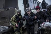 An elderly man is helped by a Ukrainian soldier as civilians are evacuated from the eastern city of Debaltseve, on February 3, 2015