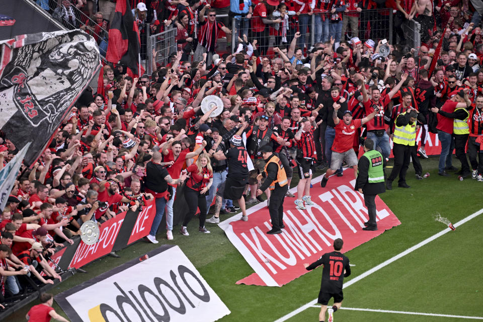 Leverkusen's Florian Wirtz, bottom, celebrates after scoring his side's fourth goal of the game during the Bundesliga soccer match between Bayer Leverkusen and Werder Bremen at the BayArena in Leverkusen, Germany, Sunday April 14, 2024. (David Inderlied/dpa via AP)