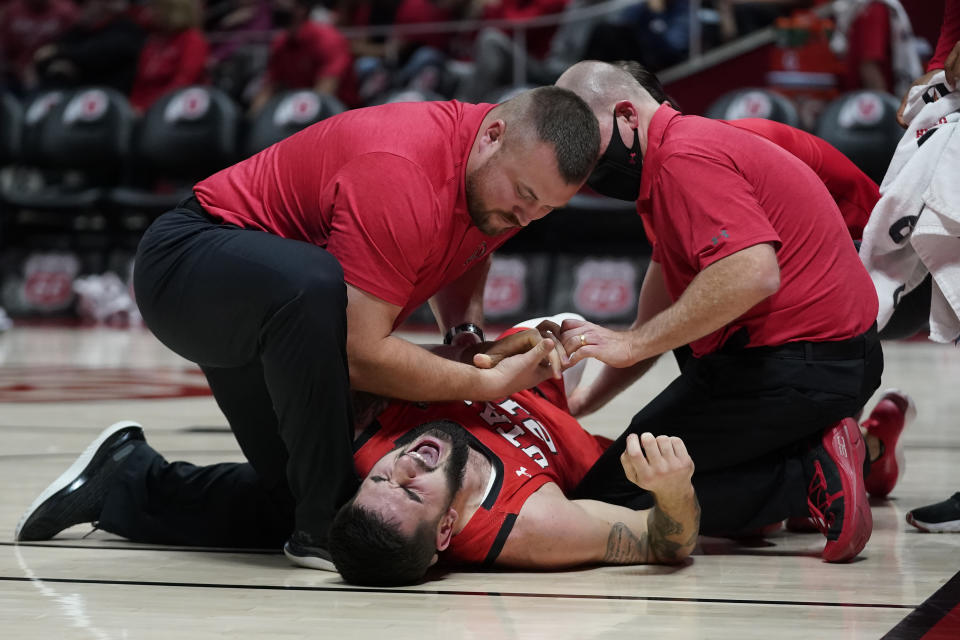 Utah forward Dusan Mahorcic (21) shouts after falling to the floor in the first half during an NCAA college basketball game against BYU Saturday, Nov. 27, 2021, in Salt Lake City. (AP Photo/Rick Bowmer)